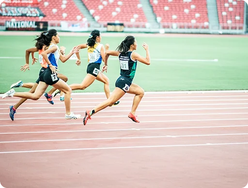 Estafeta a fazer a passagem do testemunho na final dos 4 x 100 metros durante um grande torneio internacional de atletismo num dia de sol